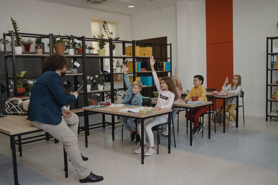 Students actively participating by raising hands in a modern classroom